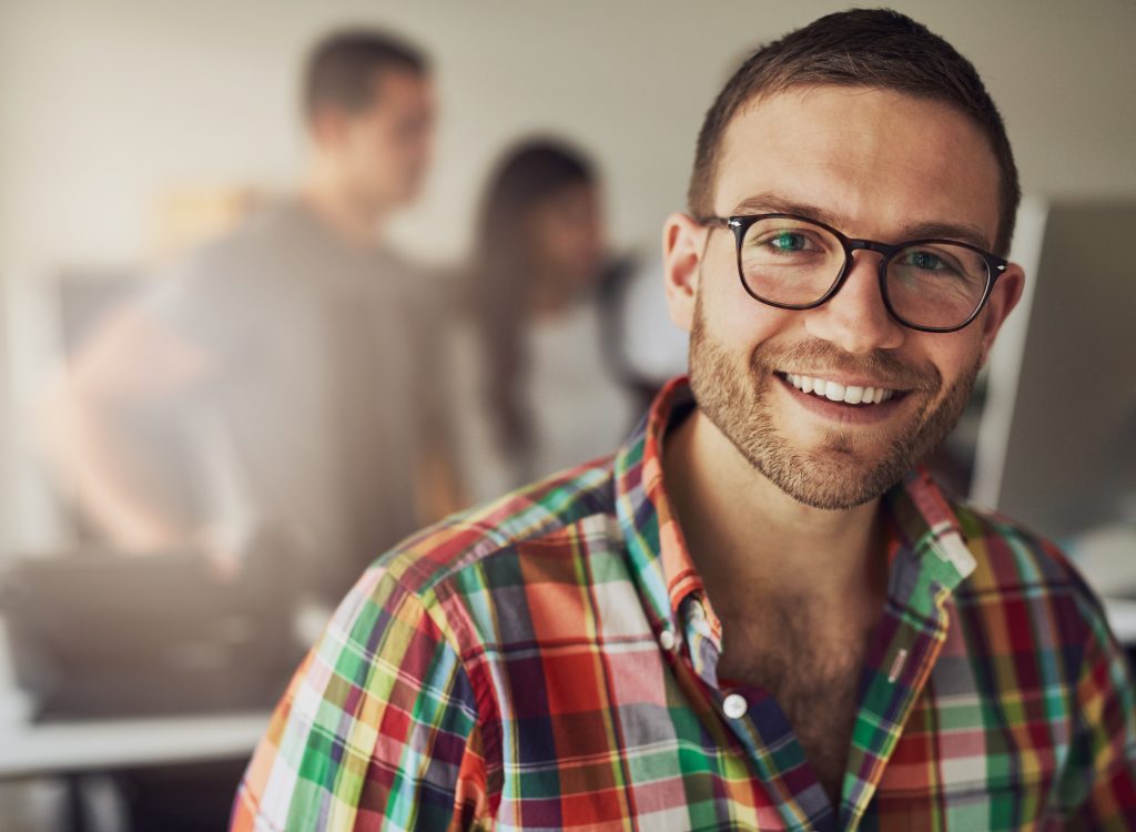 Horizontal portrait of a smiling office working man looking at camera.